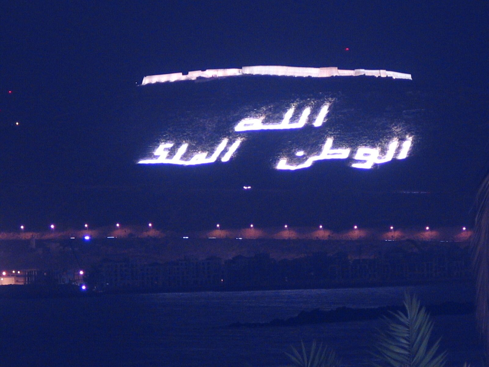 Agadir Oufella kasbah lit up at night above the city, Morocco