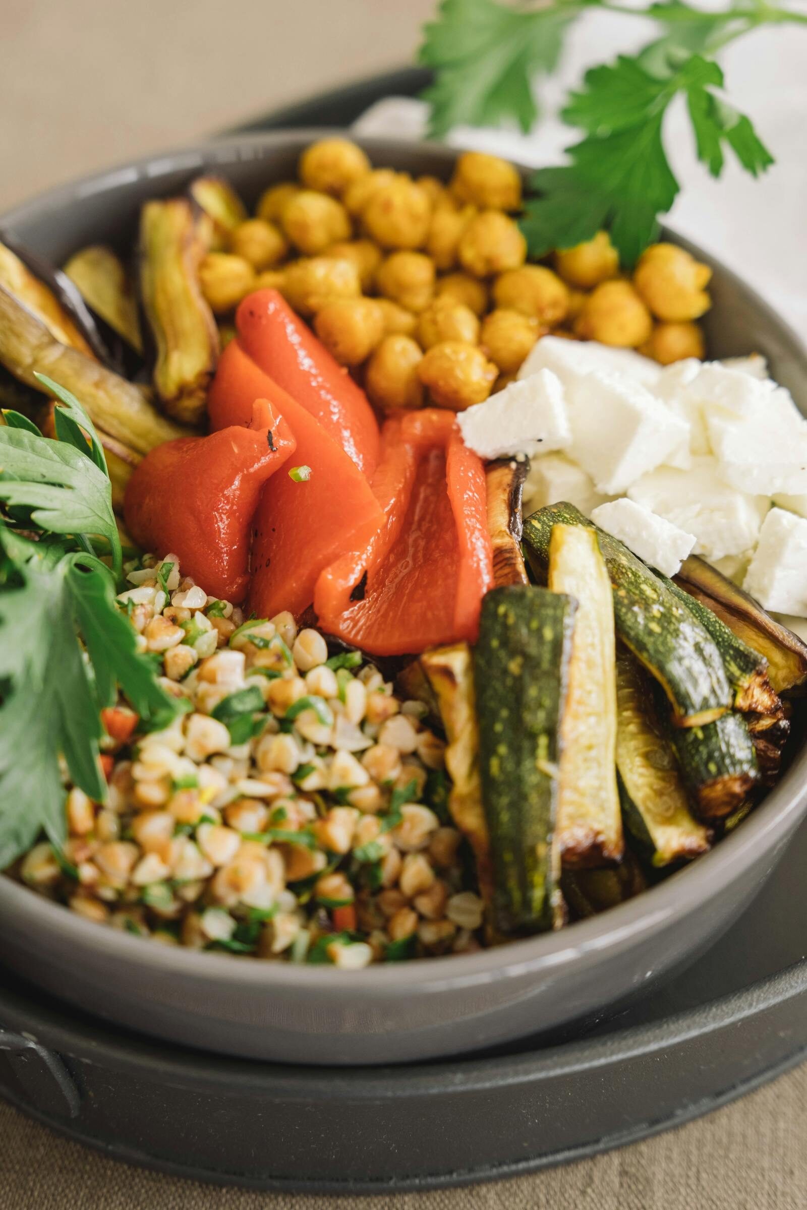 Composed Mediterranean bowl with grains, vegetables, and protein