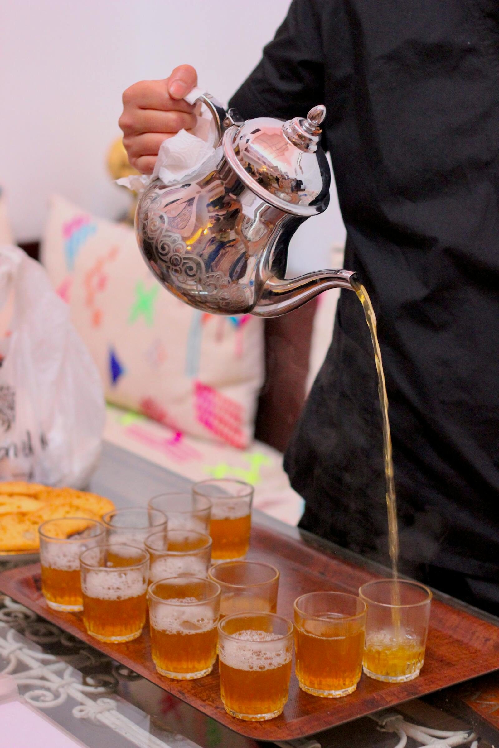 Moroccan mint tea being poured high into a glass, traditional service