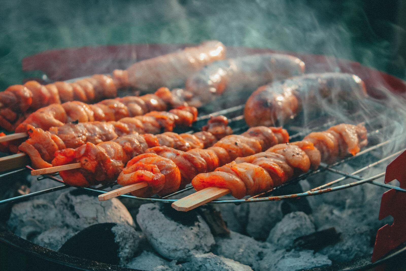 Moroccan charcoal grill in action with skewers and meat searing under smoke, of the type Mister Cook uses