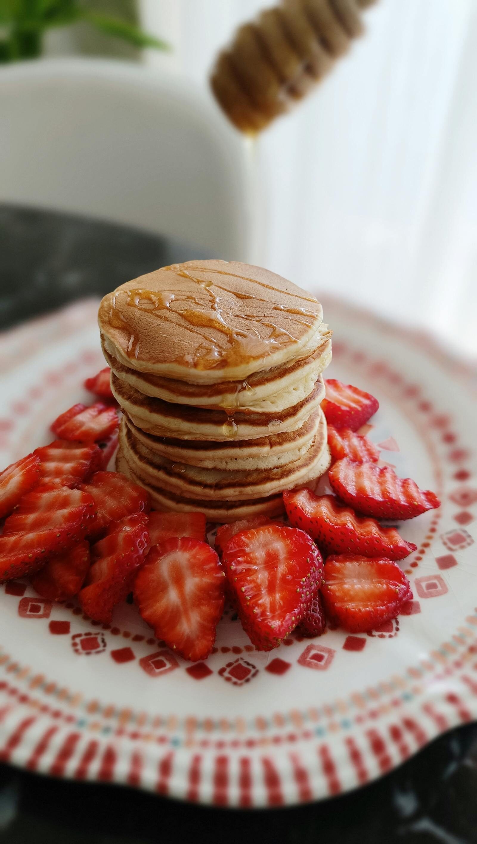 Stack of pancakes with strawberries and honey, classic sweet brunch plate at TamTam Agadir