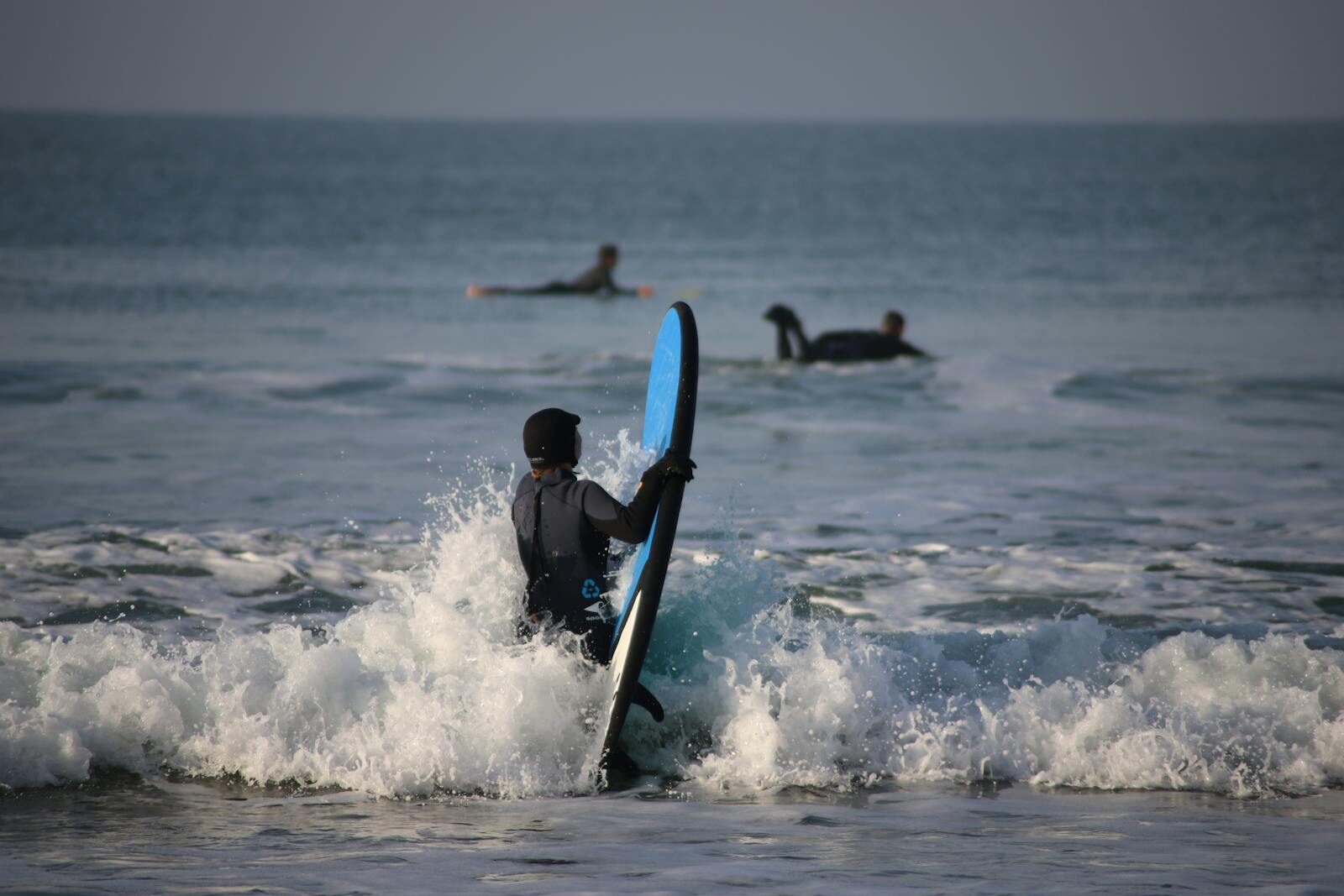 Mellow beginner-friendly wave at a Moroccan beach break, multiple learners on whitewash