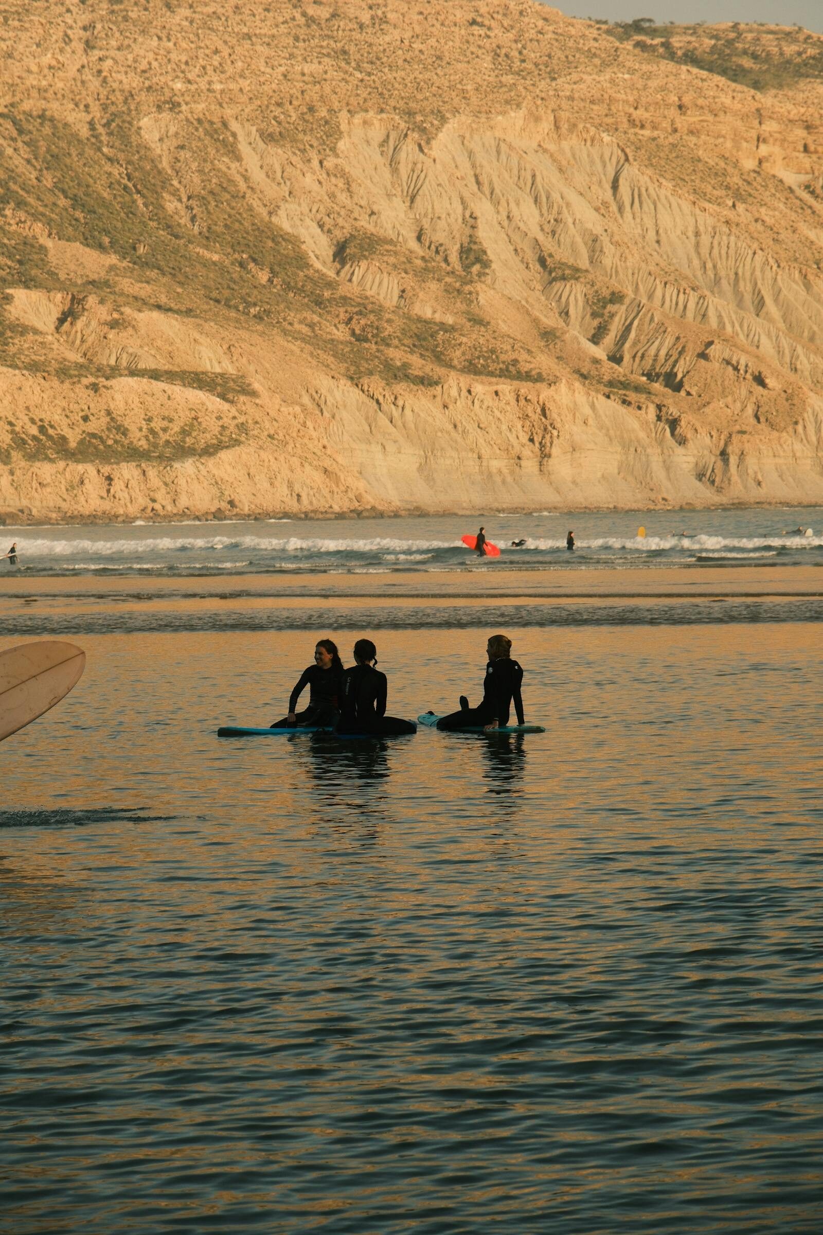Surfers paddling out at dawn on a Moroccan beach